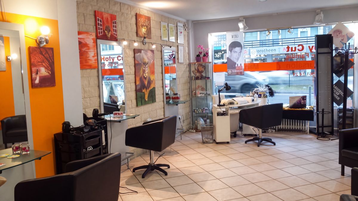 Innenraum von HOLYCUT mit Friseurplätzen, Gemälden und großer Schaufensterfront